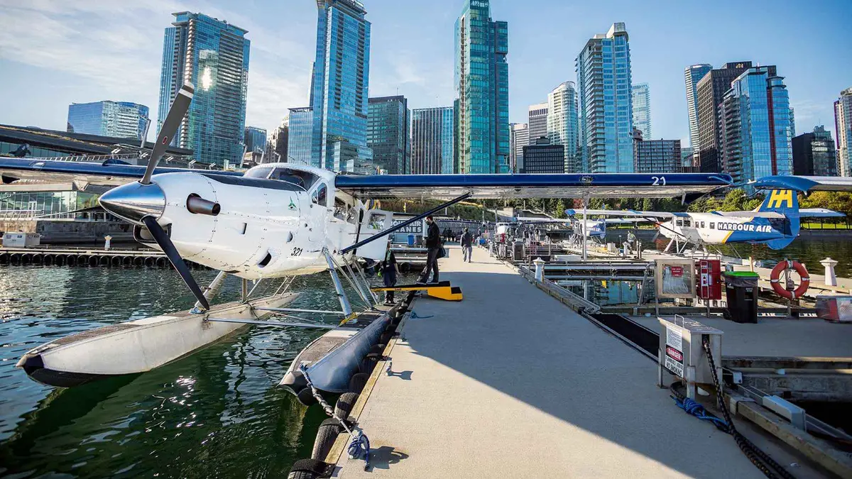 Harbour Air floatplane banking over Stanley Park and the Lions Gate Bridge, Vancouver panorama seaplane tour
